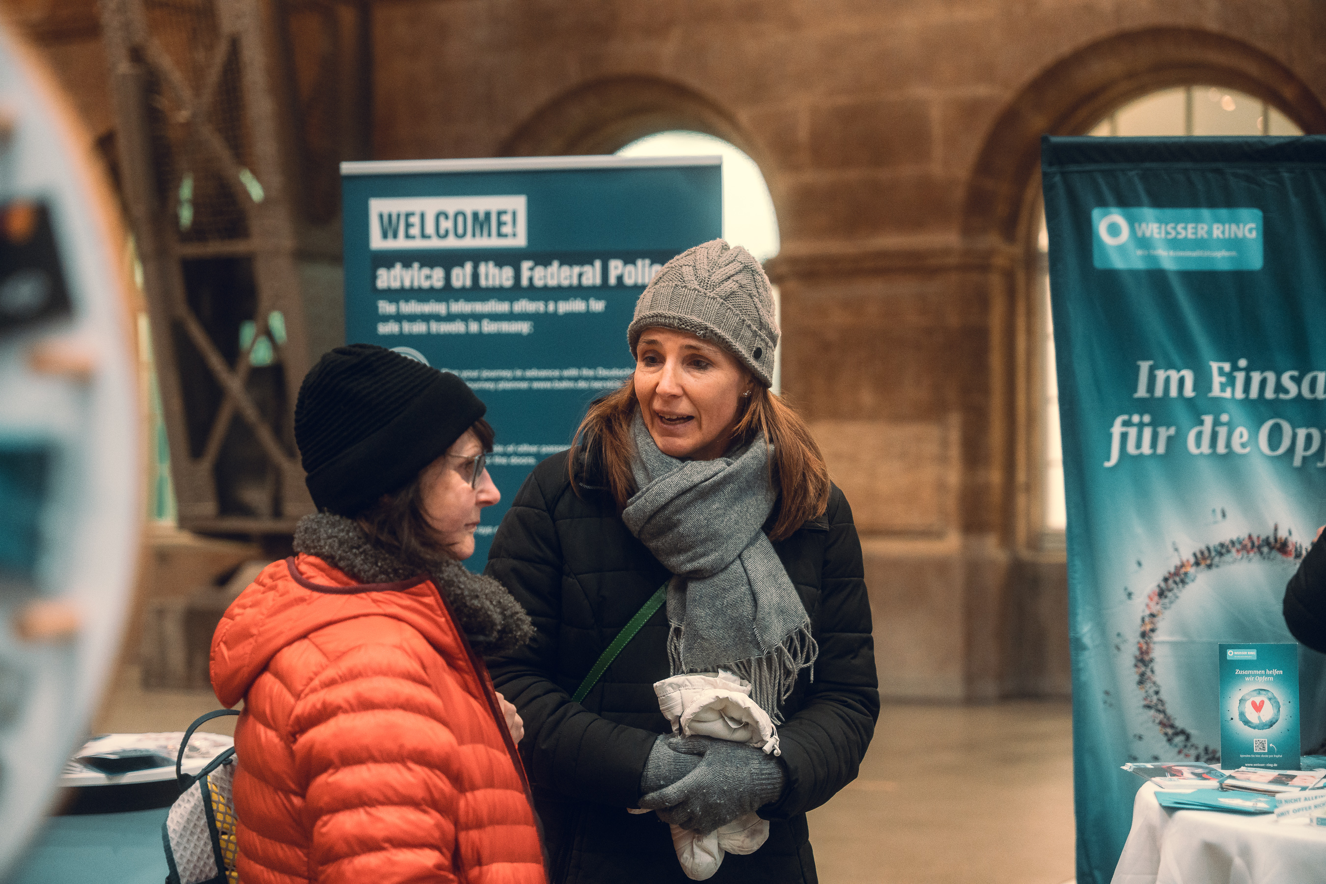 Mitarbeiterin des WEISSEN RING informiert Reisende